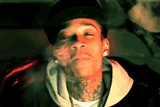 a man with a tattoo on his neck smoke a cigarette