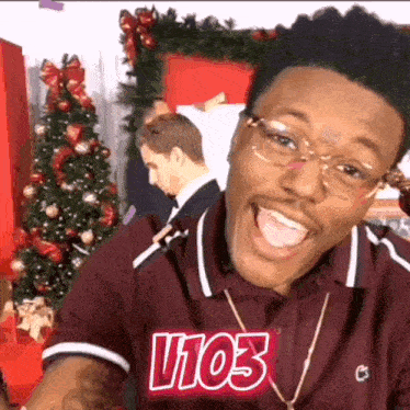 a man wearing glasses and a shirt that says v103 on it