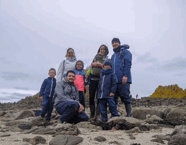 a group of people posing for a picture on the beach