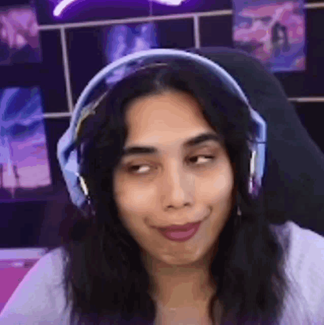 a woman is wearing headphones and making a funny face while sitting in a chair .