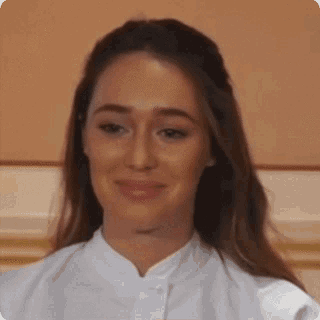 a close up of a woman 's face with a white shirt on .
