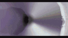 a close up of a purple object with a black hole in the middle of it .