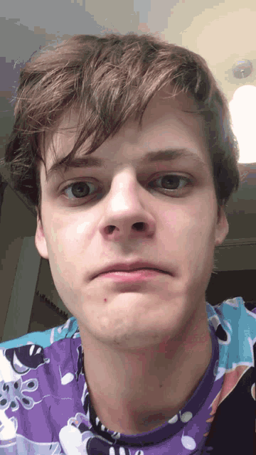a young man wearing a purple shirt with a pattern of octopus on it