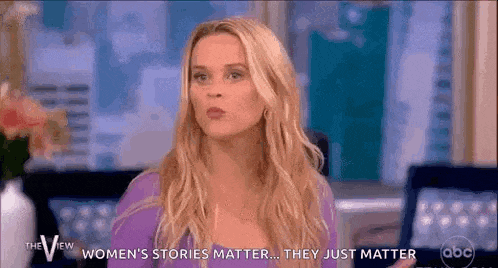 a woman is talking on a television show while wearing a purple shirt .