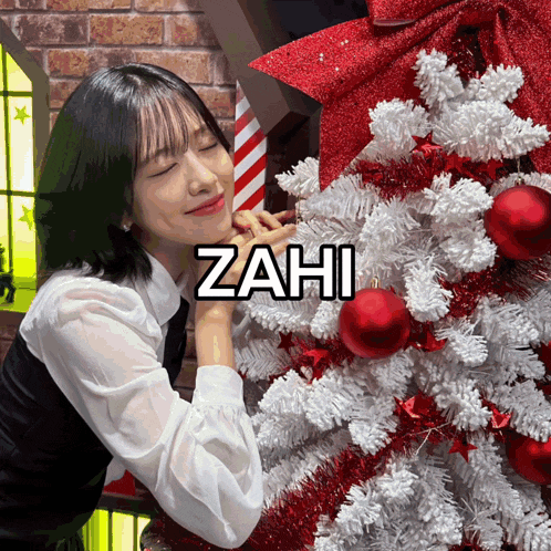 a woman standing next to a christmas tree with the name zahi on the bottom