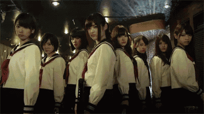 a group of girls in school uniforms are standing in a row