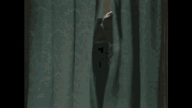 a man in a suit and tie is looking through a window