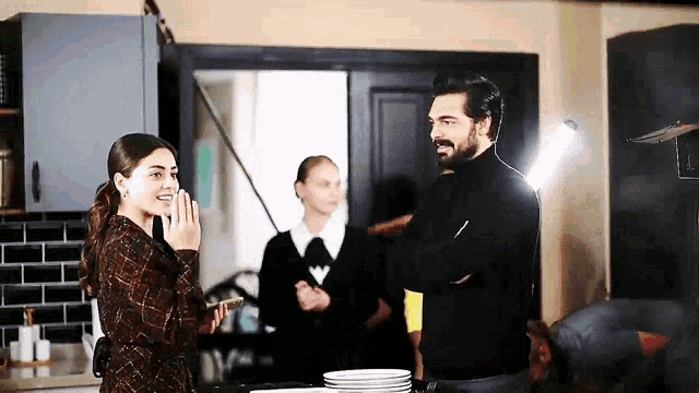 a man and a woman are standing in a kitchen with plates on the counter