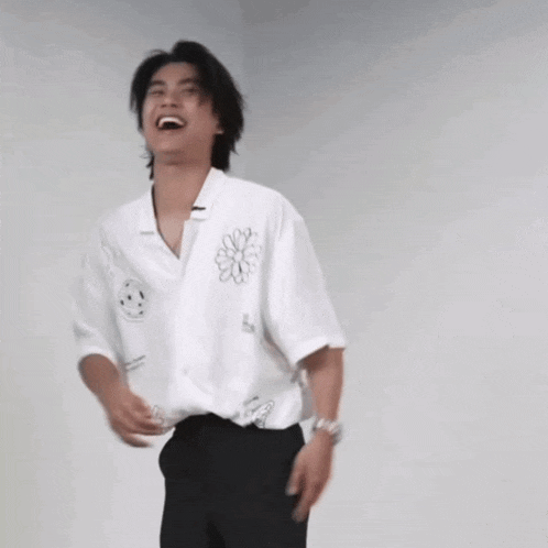 a man in a white shirt and black pants is laughing