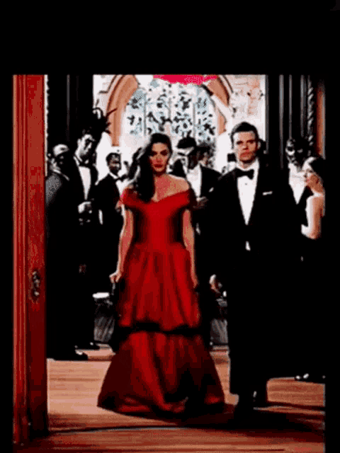 a woman in a red dress and a man in a tuxedo