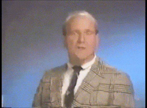 a man in a plaid jacket and tie is dancing