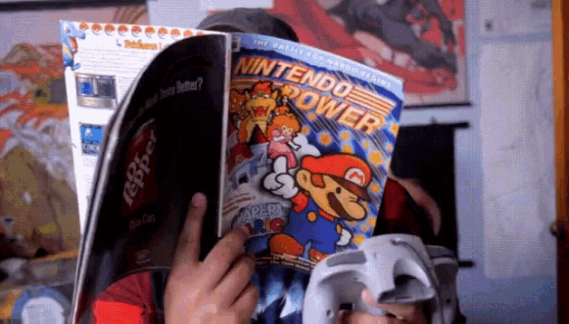 a person holding a nintendo power magazine in front of their face