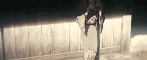 a person in a kimono is standing in front of a wooden fence .