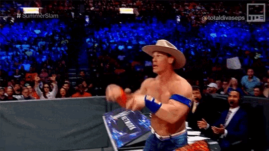 a man in a cowboy hat is pointing at something in front of a crowd