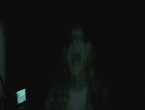a dark room with a computer monitor displaying a screen that says ' a ' on it