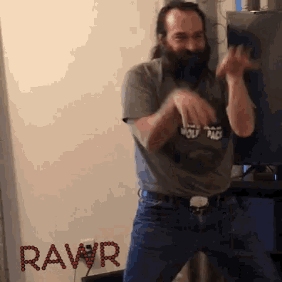 a man with a beard is dancing in front of a wall that has the word rawr on it