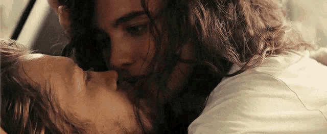 a man and a woman are kissing in a car .