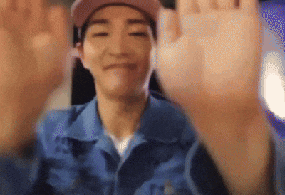 a man wearing a pink hat and a blue shirt is waving