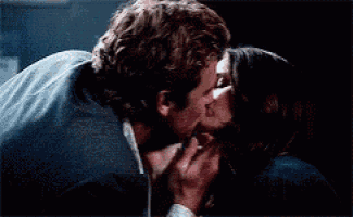 a man and a woman are kissing in the dark .
