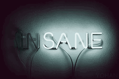 a neon sign that says insane on a dark wall