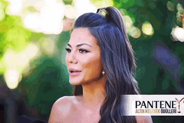 a woman with a ponytail and a pantene logo in the background