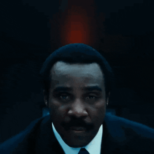 a man in a suit and tie has a blue lanyard around his neck that says ' id '