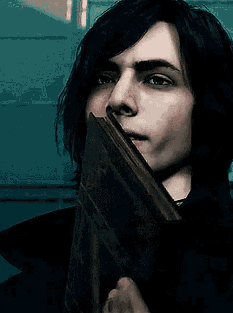 a man with long black hair and a tattoo on his chest looks at the camera