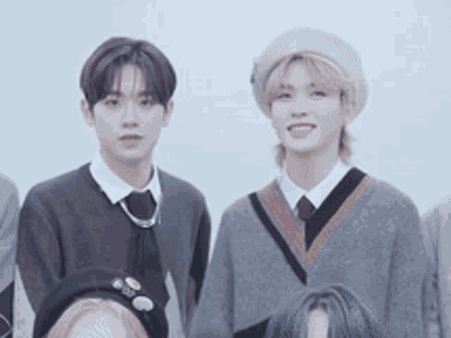a group of young men are standing next to each other wearing hats and sweaters .