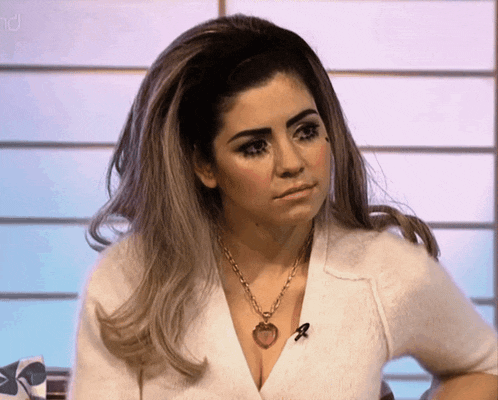 a woman wearing a white sweater and a necklace with a heart on it