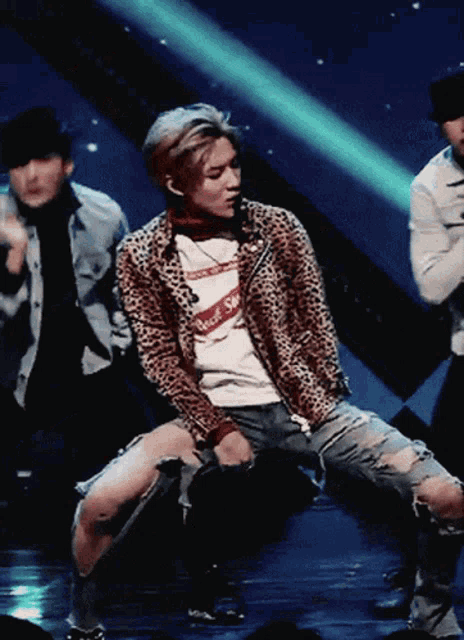 a man wearing a leopard print jacket is kneeling down
