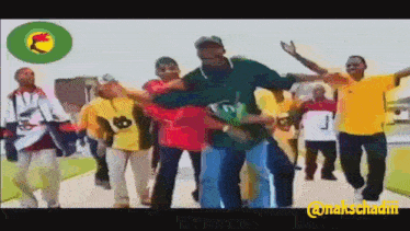 a group of people are dancing in front of a green circle with a lion on it