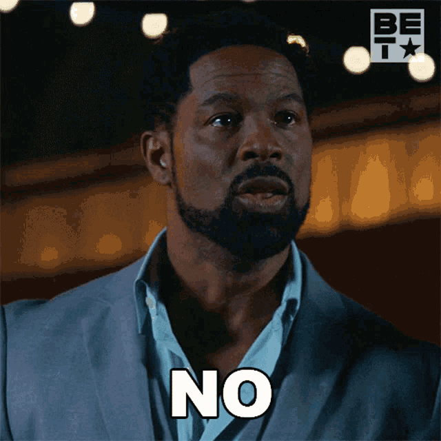 a man with a beard and a suit says " no "