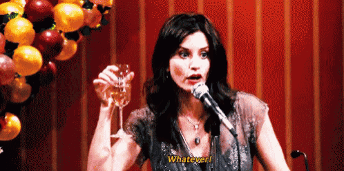 a woman is holding a glass of wine and speaking into a microphone while saying whatever .