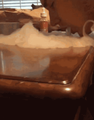 a person is taking a bath in a tub with bubbles