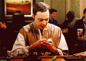 a man sitting at a table looking at his cell phone