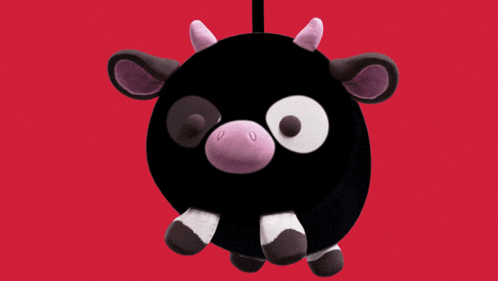 a stuffed cow with a purple nose and white eyes