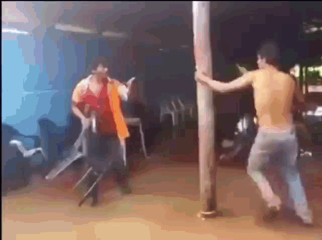 two men are standing next to each other in a room holding a pole and chairs .