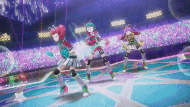 three anime girls are dancing on a stage in front of a crowd of people .
