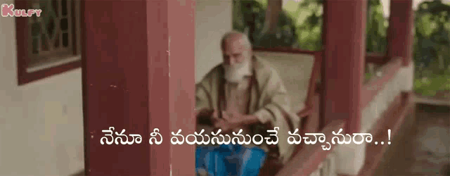 a man with a beard is sitting on a porch with a sign in a foreign language