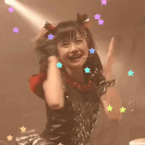a girl with a ponytail and stars on her hair is smiling