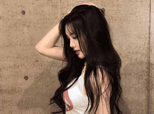 a woman with long black hair is wearing a white tank top with the letter a on it