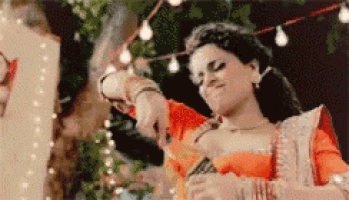 a woman in an orange dress is dancing with a man in a white shirt .