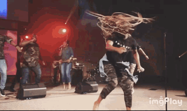a group of people are dancing in front of a microphone with the words imgplay in the corner
