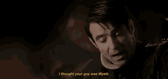 a man is talking to another man in a dark room .