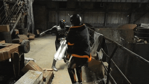 a man in a skeleton costume is fighting another man in a black and orange outfit