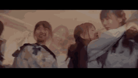 a group of young women are standing next to each other in a room and dancing .