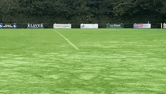 a soccer field with several advertisements including one for klaver