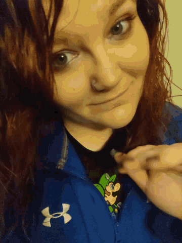 a woman is wearing a blue under armour sweatshirt