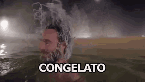 a man with a beard is swimming in a pool of water with ice on his head .