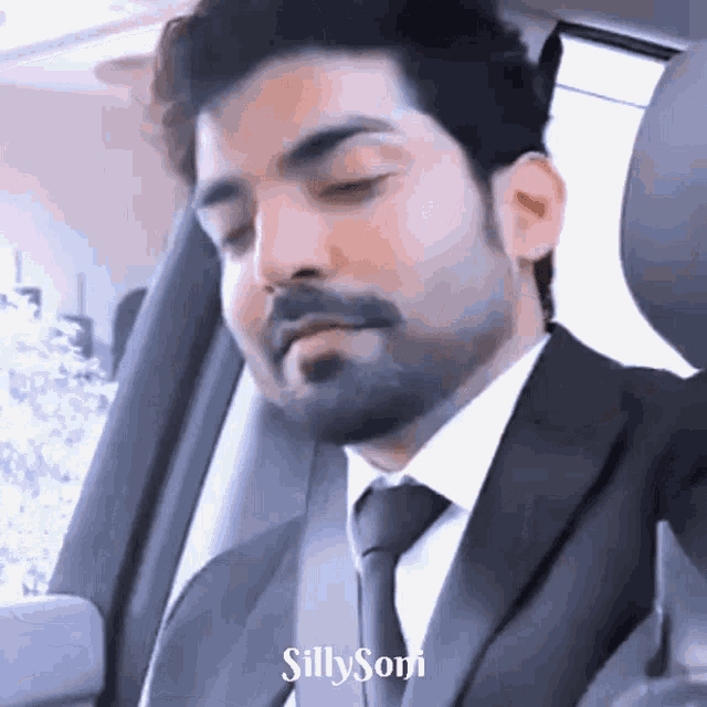a man in a suit and tie is sitting in a car with the words silly soni on the bottom